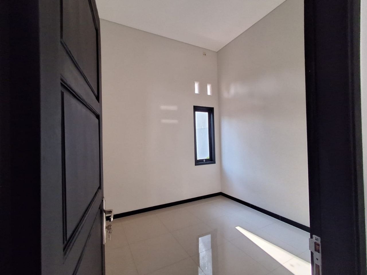 Kamar tidur rumah baru minimalis Gunungpati Semarang, pintu mahoni, jendela tinggi, lantai granit