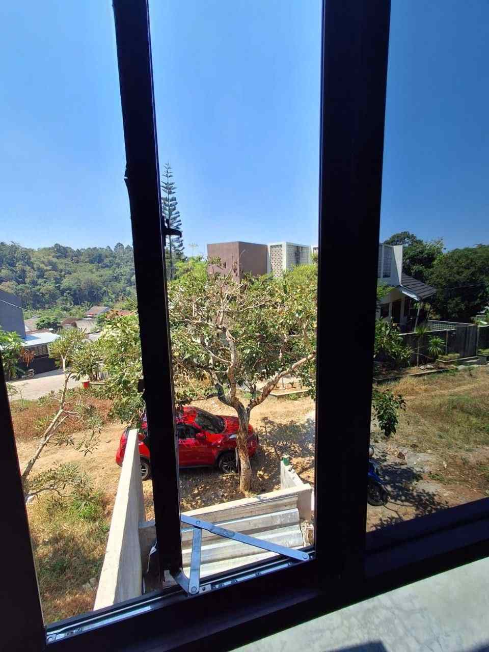View luar rumah Megah Residence 2 Gunungpati Semarang, jendela besar menghadap pepohonan dan perbukitan, suasana asri dataran tinggi