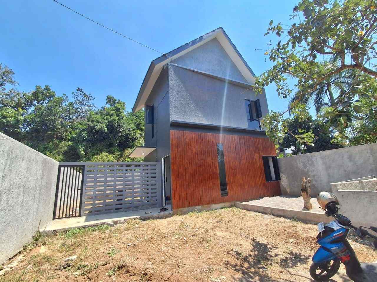 Tampak pagar dan carport rumah Megah Residence 2 Gunungpati Semarang, pagar besi kombinasi roster, motor parkir di carport, halaman tanah siap taman