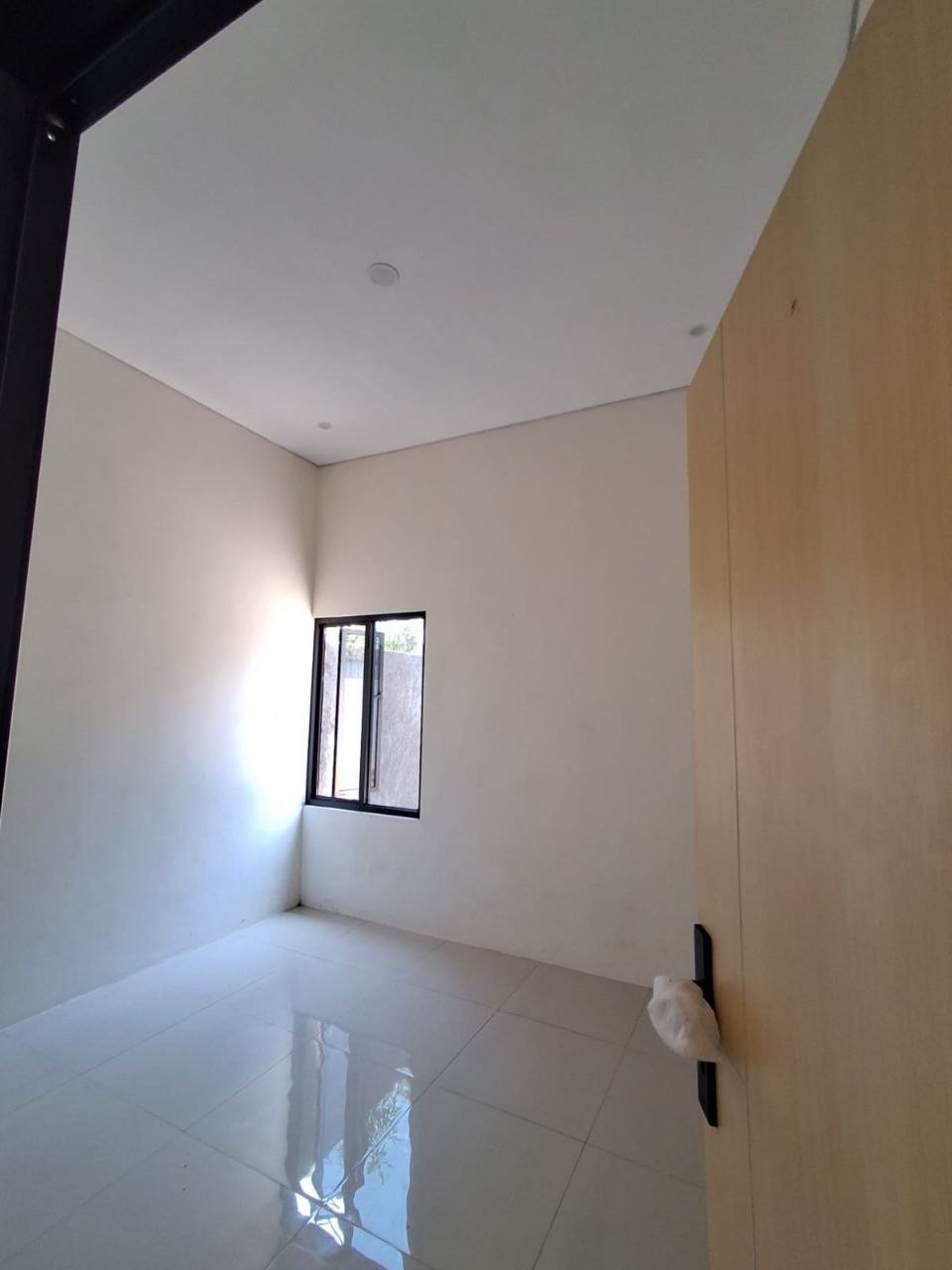 Kamar tidur kedua rumah Megah Residence 2 Gunungpati Semarang, jendela besar menghadap taman, lantai granit, pintu kayu finishing natural